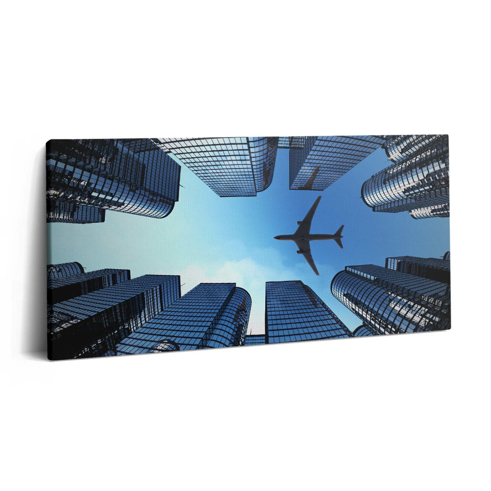 Obraz na plátně 100x50 cm Letadlo nad budovami